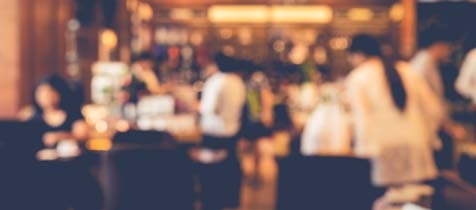 Blurred shot of a busy restaurant with many waiters and customers